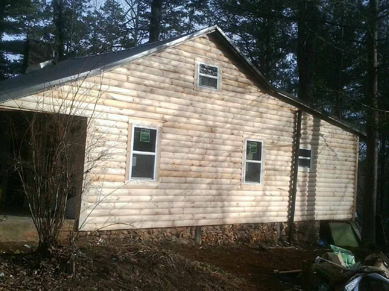 New log siding and dark metal roofing on a gable end in Glen Campbell