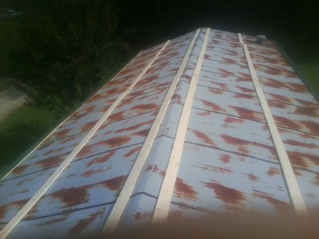 Rusted metal roof panels with new wood purlins before replacement — Storm Damage Roof Repair in Glen Campbell by Roofing Brothers