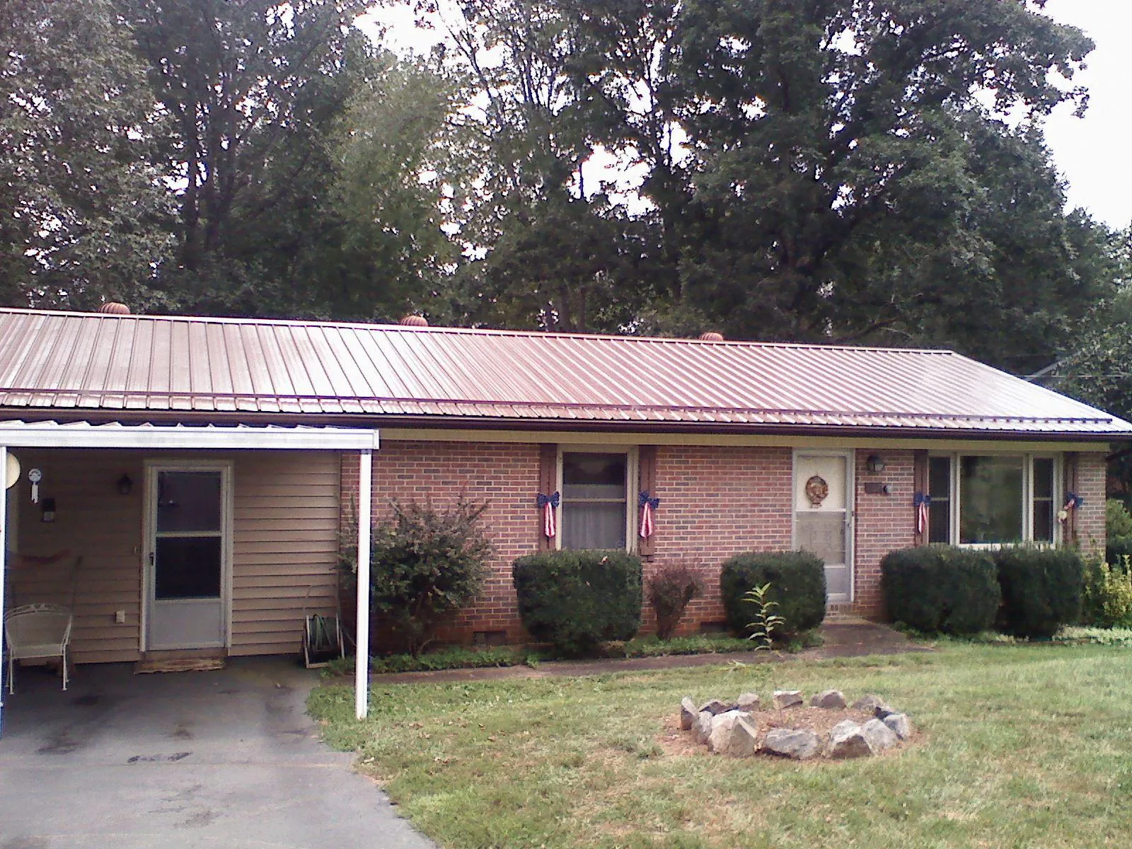 Bronze metal roof and carport on a brick ranch home — Roof Repair work by our crew in Glen Campbell